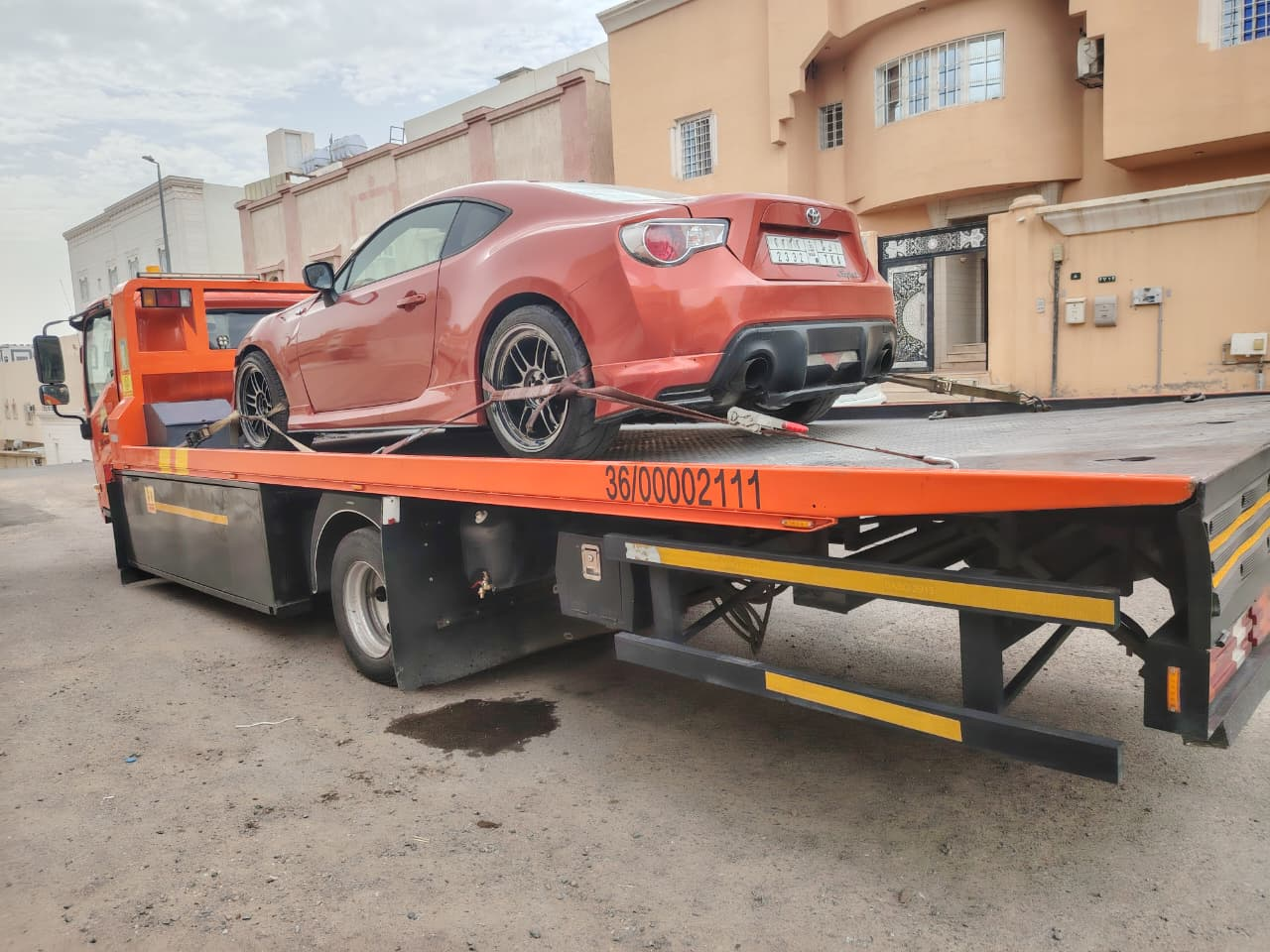 سطحة تنقل تويوتا GT86 برتقالية من حي سكني